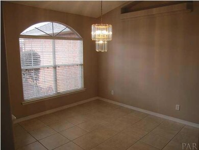 Formal dining room with tile flooring, chandelier on dimmer & lighted plant ledge. Kitchen to your right.
