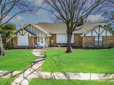 Tudor-style house with brick siding, a front yard,