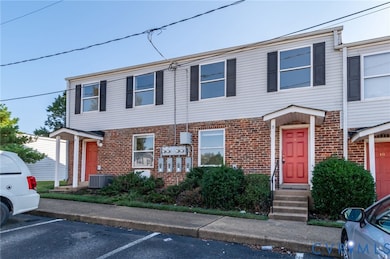 Traditional home with uncovered parking and brick siding