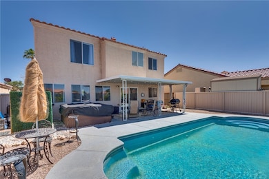 View of swimming pool featuring a hot tub, a patio
