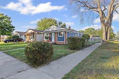 Bungalow-style home with brick siding, a front lawn, a chimney, and board and batten siding