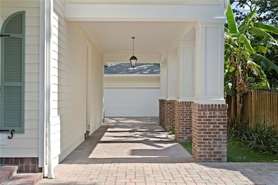 A wide driveway and porte cochere provide convenience, charm, and room for multiple vehicles.