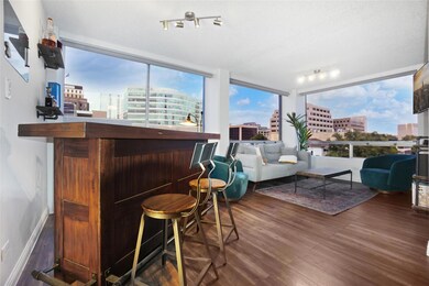 Indoor dry bar with dark wood finished floors, a city view, and expansive windows