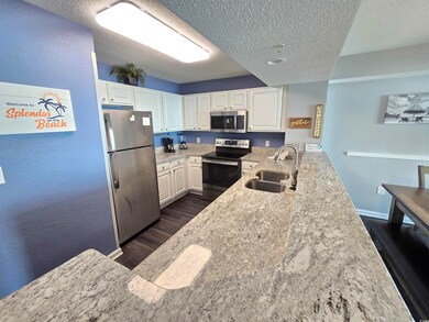 Kitchen with light stone countertops, appliances w