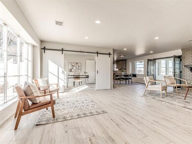 Living room featuring a barn door and light hardwo