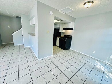 Kitchen with black appliances, a textured ceiling