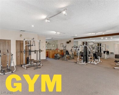 Workout area with a textured ceiling and track lig