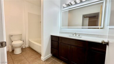 Full bathroom featuring baseboards, toilet, tile p