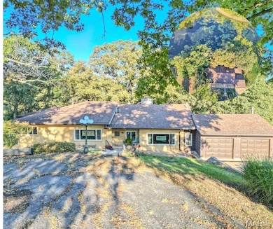 View of front of home with a chimney and a garage