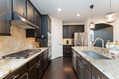 Gourmet kitchen with expansive granite island, sta