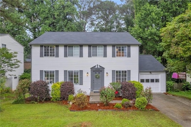 Colonial home with driveway, a garage, and a front yard