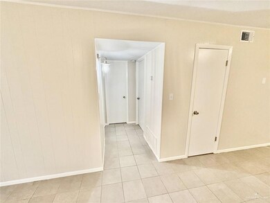 Hall featuring light tile patterned floors and crown molding