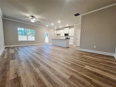 Unfurnished living room featuring ornamental molding, wood finished floors, a ceiling fan, and recessed lighting