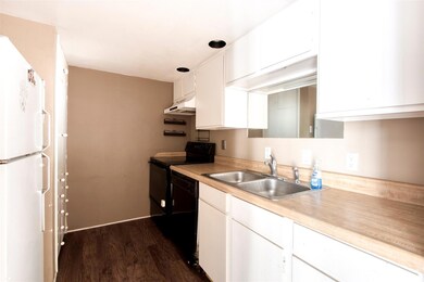 Kitchen featuring black dishwasher, dark wood-type