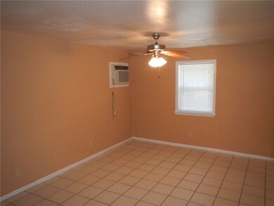 Unfurnished room featuring ceiling fan, an AC wall