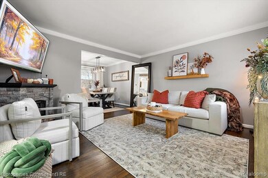 Living area with wood finished floors, ornamental molding, a fireplace
