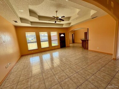 Large living room with a textured ceiling, and ceiling fan