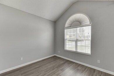 Unfurnished room featuring lofted ceiling and wood finished floors