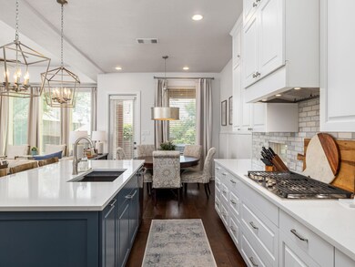 Kitchen featuring a sink, a chandelier, white cab