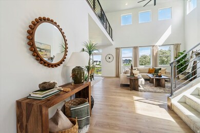 Foyer entrance featuring stairs, light wood-type flooring, and a high ceiling