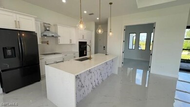 Kitchen with black appliances, a sink, exhaust hoo