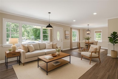 Living room featuring dark wood-type flooring, crown molding, and recessed lighting