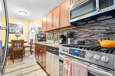 Kitchen featuring a sink, brown cabinetry, light wood-style flooring, stainless steel appliances, and decorative backsplash