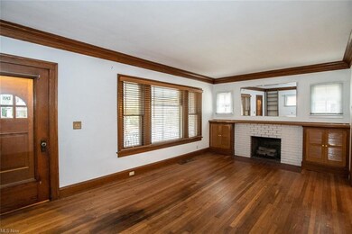 The living room features a decorative brick fireplace, built-in cabinets, and wood floors