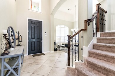 Upon entering the home, you're welcomed by high ceilings in the foyer, creating a spacious and airy atmosphere. Tile flooring extends from the foyer into the living room and kitchen, adding to the seamless flow of the space.