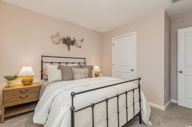 Bedroom with light carpet and baseboards