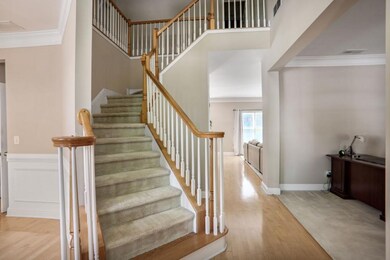 Elegant 2-story foyer featuring a grand curved staircase, soaring ceilings, and abundant natural light perfect for making a stunning first impression