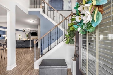 Staircase with wood finished floors, a fireplace, and a high ceiling
