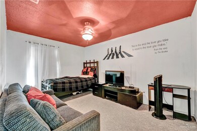 Carpeted bedroom with a textured ceiling, ceiling fan, and baseboards
