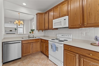 Kitchen featuring white appliances, brown cabinetr