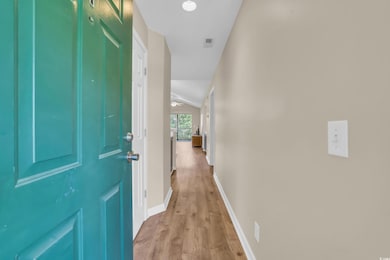 Hall featuring visible vents, light wood finished 