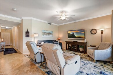Living room with a ceiling fan, crown molding, til