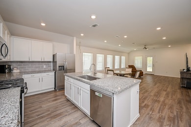 White cabinetry, Granite countertops, Central island, Light gray subway tile backsplash.

