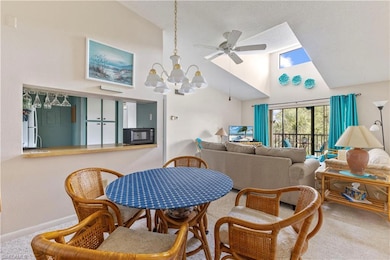 Carpeted dining area featuring a ceiling fan, high vaulted ceiling, a chandelier, and baseboards
