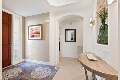 Entryway with light tile patterned floors, arched 