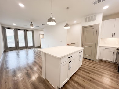Kitchen with a center island, ceiling fan, hardwoo
