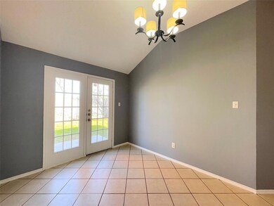 Doorway with a chandelier, light tile patterned fl