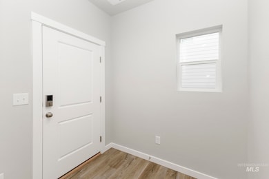 Unfurnished room with light wood-style floors and baseboards