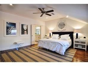 Bedroom with dark wood-style floors, a ceiling fan, and vaulted ceiling