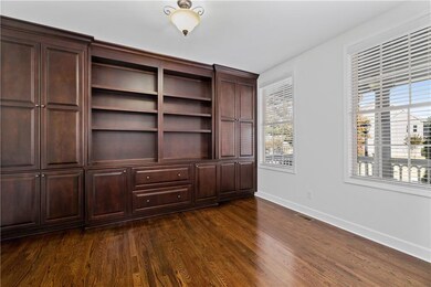 Unfurnished bedroom with dark wood-style floors and baseboards