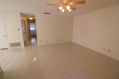 Empty room featuring a ceiling fan, light tile pa