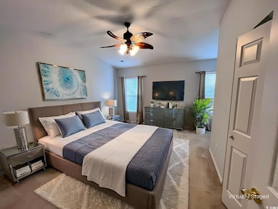 Bedroom featuring ceiling fan, light colored carpe