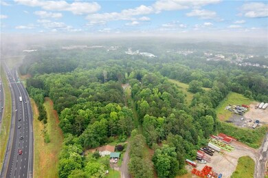 North Facing View from the end of road. Wooded area is part of the 27 acres.  I-575 to left of screen with Sixes Road exist top left