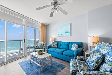 Living area featuring light wood-type flooring, a ceiling fan, and a water view
