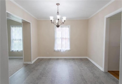 Unfurnished room featuring a chandelier, plenty o