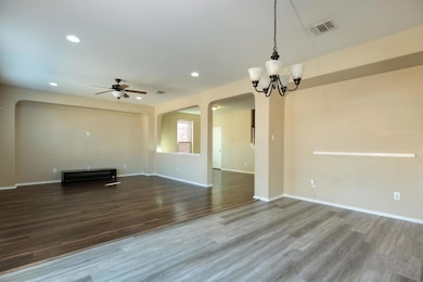 Unfurnished living room featuring arched walkways